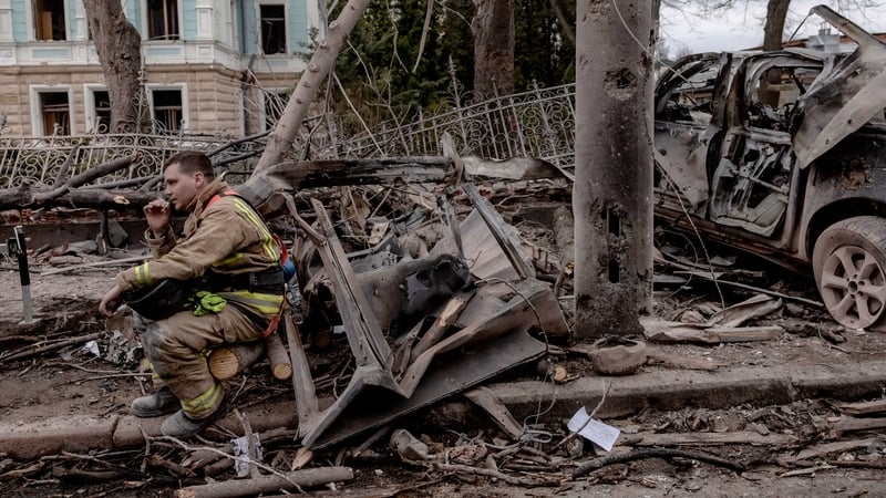 A Ukrainian rescue worker takes a break at the site of the missile attack in Sumy