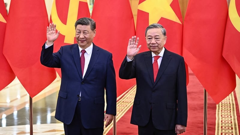 Vietnam's communist party General Secretary Tô Lâm (R) and Chinese President Xi Jinping (L) wave during a meeting at the Office of the Party Central Committee in Hanoi