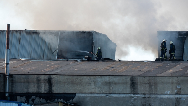 Rescuers extinguish a fire after a Russian UAV hit a food warehouse in Kharkiv, Ukraine