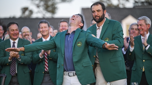Scottie Scheffler presents Rory McIlroy his new item of clothing during the green jacket and trophy presentation ceremony at Augusta
