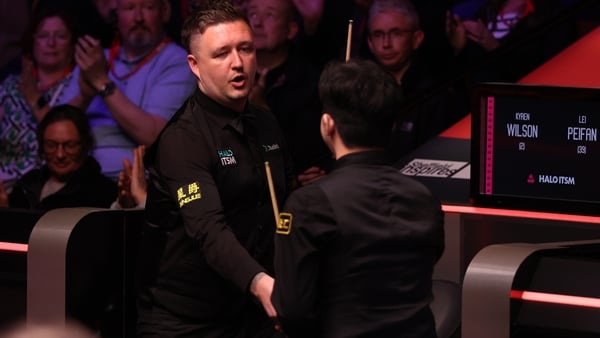 Kyren Wilson shakes hands with Lei Peifan after their match