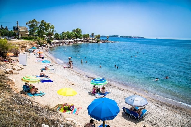 People relaxing on a beach in Voula, a southern suburb of Athens