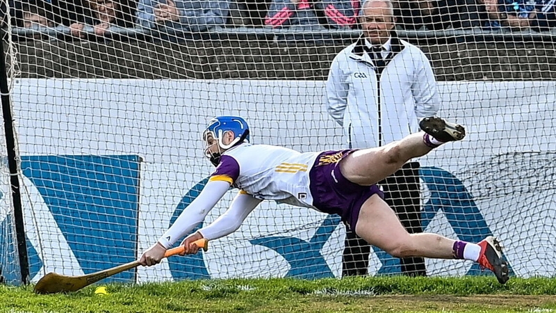 Wexford goalkeeper Mark Fanning dives to stop a penalty taken by Sean Currie