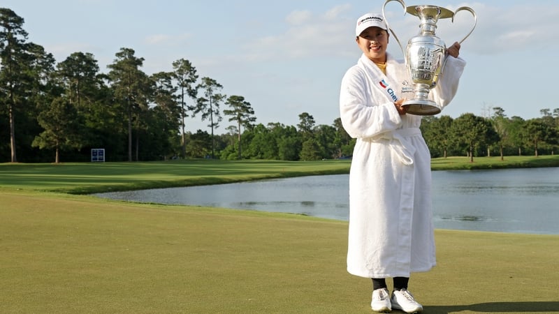 Mao Saigo with the trophy having taken the traditional winning dip in the lake by the 18th green