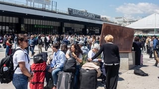 Passengers wait outside Sants station in Bareclona
