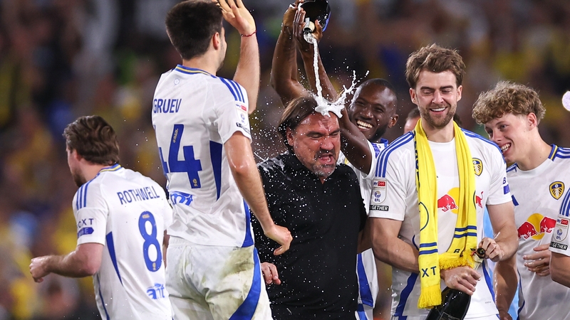 Josuha Guilavogui of Leeds United pours champagne over manager Daniel Farke
