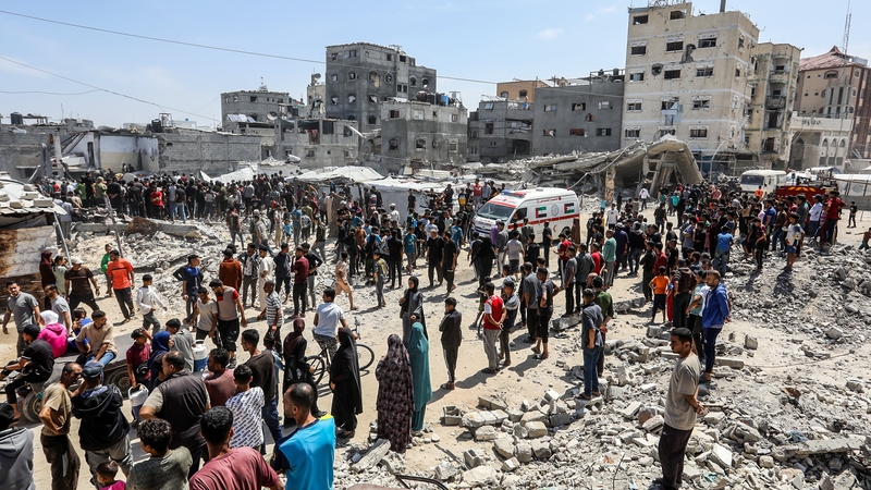 Civil defense teams and residents carry out a search and rescue operation after Israeli attacks on Khan Younis, Gaza