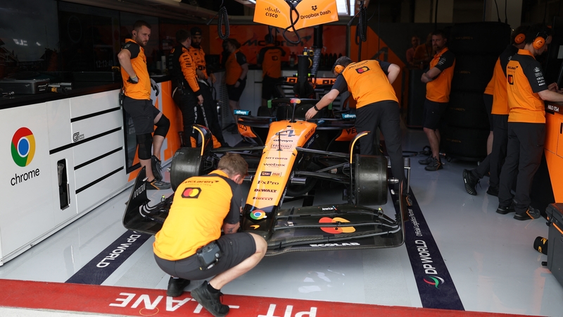 McLaren technicians work on Lando Norris' car during practice at Miami