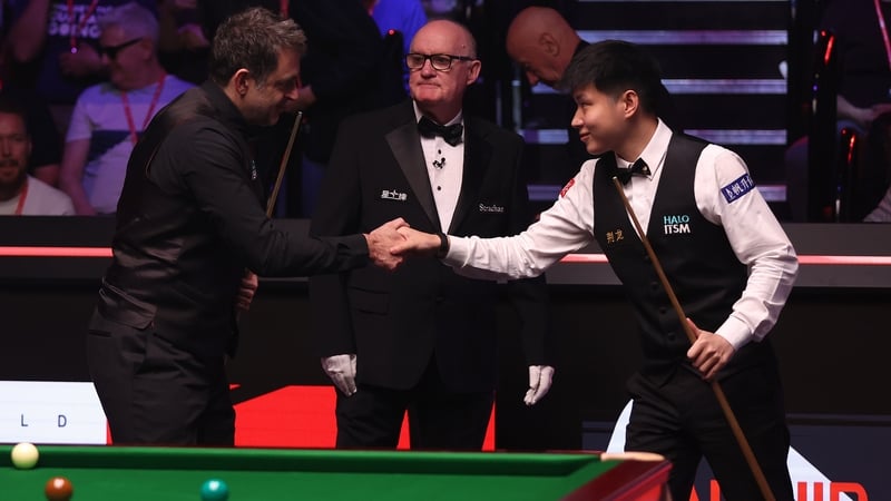 Ronnie O'Sullivan (L) shakes hands with the winner Zhao Xintong