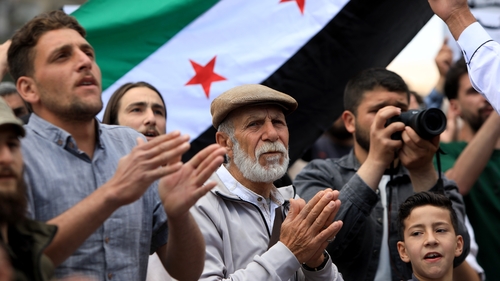 Dozens of people gather near Damascus to hold a protest against the Israeli airstrikes