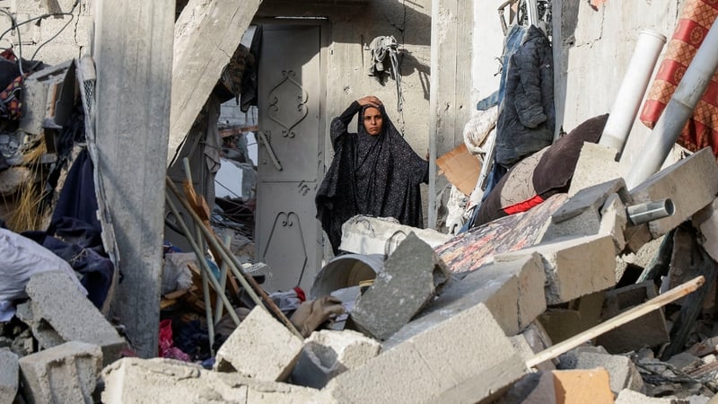 A woman inspects the damage on a house from an Israeli strike in Khan Younis today
