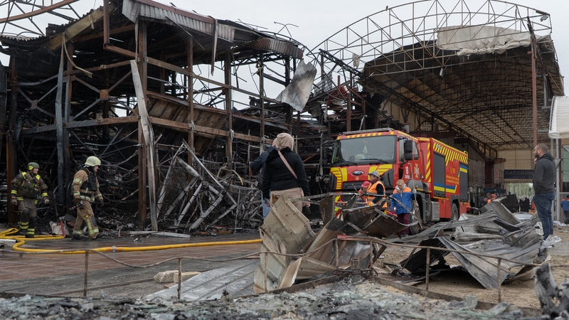 Firefighters work at the site of a separate Russian drone strike on the Barabashovo market in Kharkiv