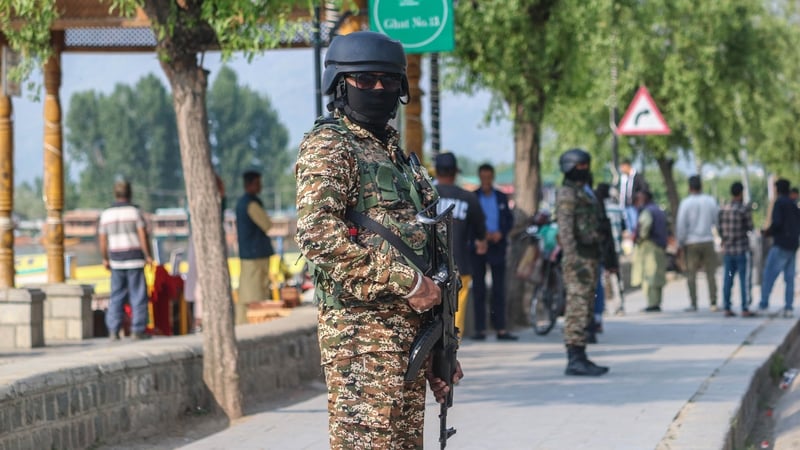 Indian paramilitary soldiers standing guard along the banks of Dal Lake earlier today