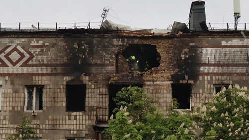 Ukrainian rescuers work inside a residential building damaged during a Russian drone attack