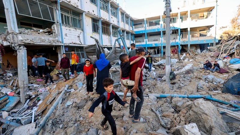 Palestinians check the destruction at a UNRWA school housing displaced people, following an Israeli strike in the Bureij refugee camp