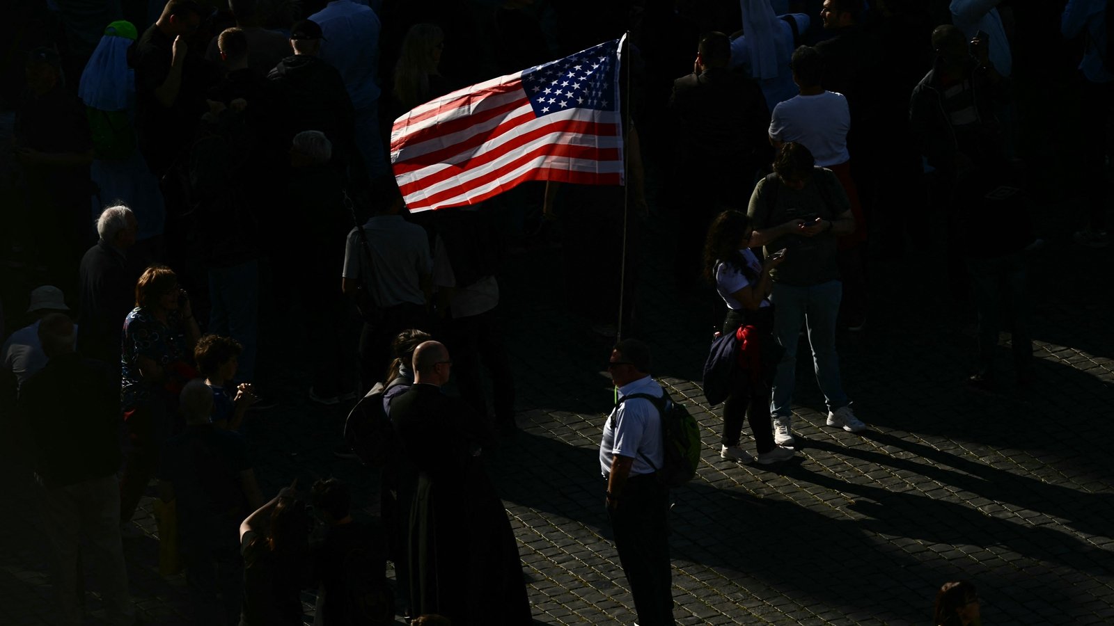 A man holding a US flag was seen standing amid the crowds in St Peter's Square. A sign of things to come...