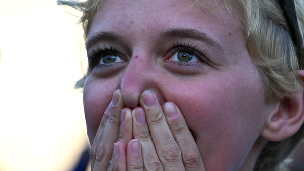 A woman reacts after white smoke rose from the chimney of the Sistine Chapel