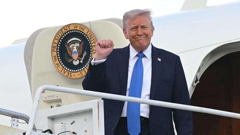US President Donald Trump raises a fist as he steps off Air Force One