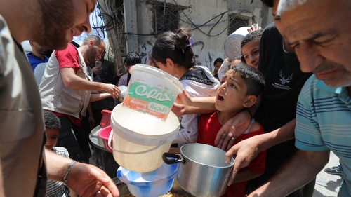 A Palestinian boy in Deir al Balah waits for aid workers to give him some food amid Israel's ongoing total blockade on Gaza