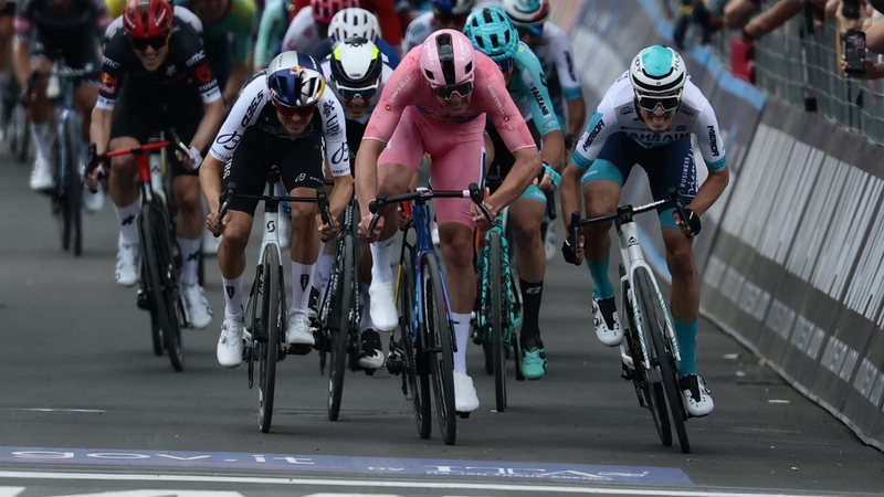 Pink jersey holder Mads Pedersen (C) sprints toward the finish line on ahead of Edoardo Zambanini (R)