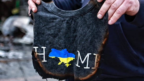 A man holds a burned T-shirt after a Russian drone strike on the Barabashovo market