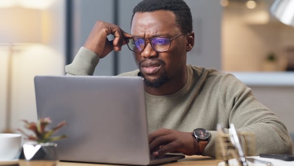 a man looking at a laptop in frustration