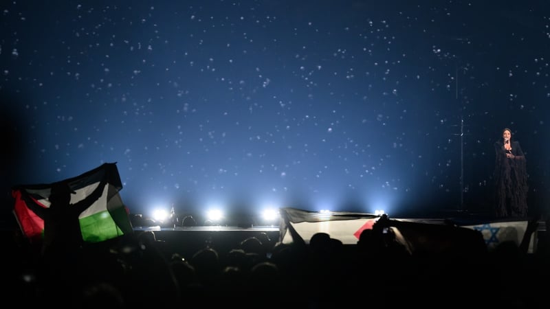 Protestors wave the Palestinian flag (L) as Yuval Raphael representing Israel performs during the rehearsal ahead of Semi Final Round 2 of the 69th Eurovision Song Contest Opening Ceremony at Messe Basel in Basel, Switzerland