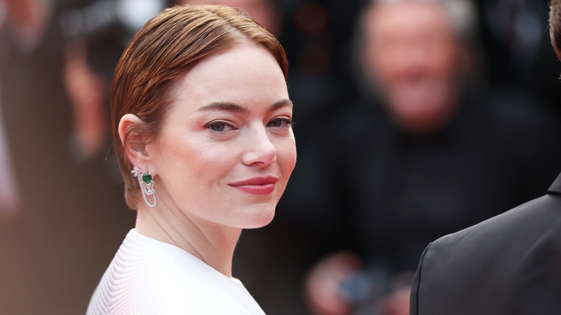 Emma Stone wore a white textured gown with emerald earrings and slicked-back hair at the premiere of Eddington