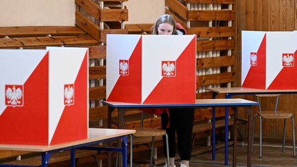 A woman casts her vote at a polling station in Warsaw