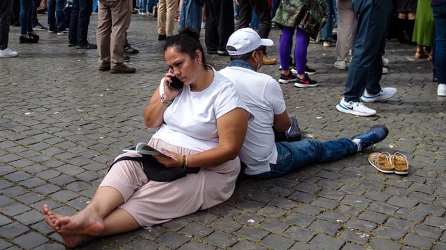 People rest on the ground in St Peter's Square