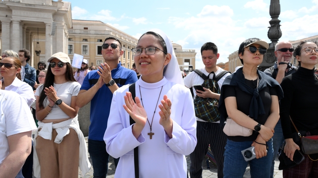 A nun and other mass goers applaud as Pope Leo leads the mass in St Peter's Square