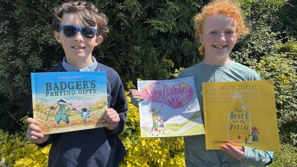 Jackson Field and Bonnie O'Meara holding some of the books that have been converted into Braille