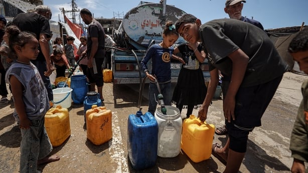 People carry jerry cans filled with water in Gaza City