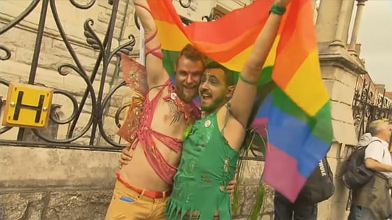 Two participants in the Pride parade in Dublin hold a rainbow flag, 2015.