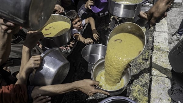 People queue for food at a distribution centre in Jabalia refugee camp