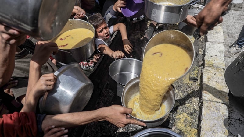 People queue for food at a distribution centre in Jabalia refugee camp