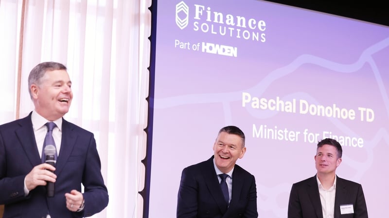 Ken Murray, Managing Director of Finance Solutions and Robert Kennedy, CEO of Howden Ireland listen to Finance Minister Paschal Donohoe at the company's new Dublin city office