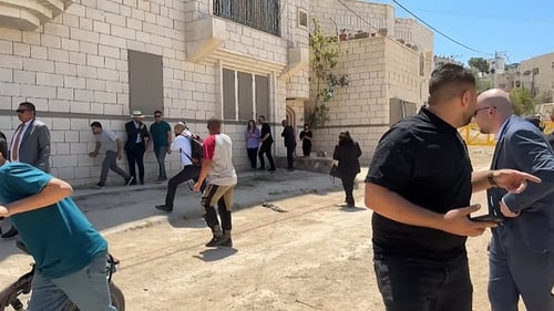 A frame grab from AFP footage shows members of the EU diplomatic delegation from the European Union reacting after shots were fired