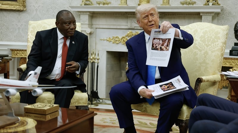 Donald Trump shows pictures and articles to Cyril Ramaphosa during their meeting in the Oval Office