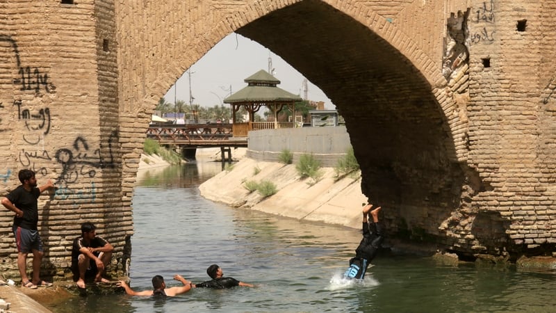 Young people seek to escape the heat in a river in the city of Karbala