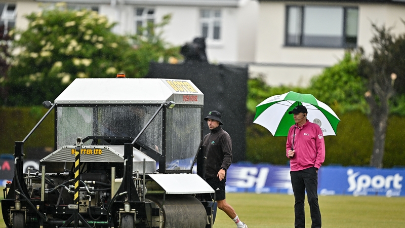 Umpire Johnny Kennedy inspects the pitch as groundstaff work on the wicket during the second match