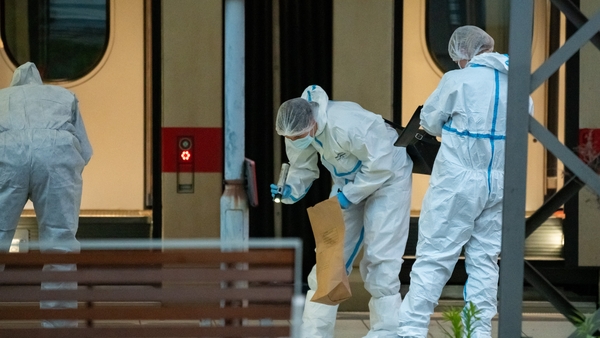 Forensic police officers investigate on the railway platform at Hamburg's main train station after a knife attack