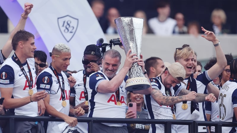 Ange Postecoglou lifts the Europa League trophy during Tottenham's open-top bus parade
