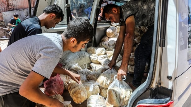 bread packages are handed over to local representatives in Khan Younis for distribution 