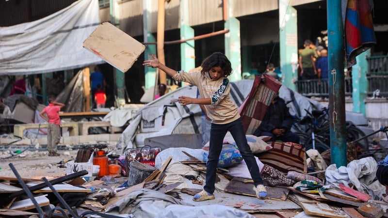 A boy sorts through belongings amid the debris at the Fahmi Al-Jarjawi School in Gaza City following an Israeli strike