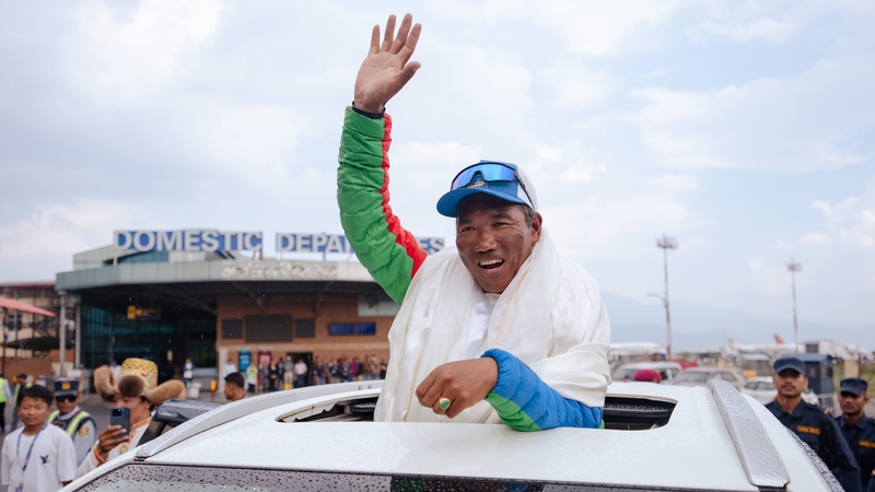 Kami Rita Sherpa waves as he arrives at Tribhuvan International Airport after scaling Mt Everest for the 30th time in May 2024