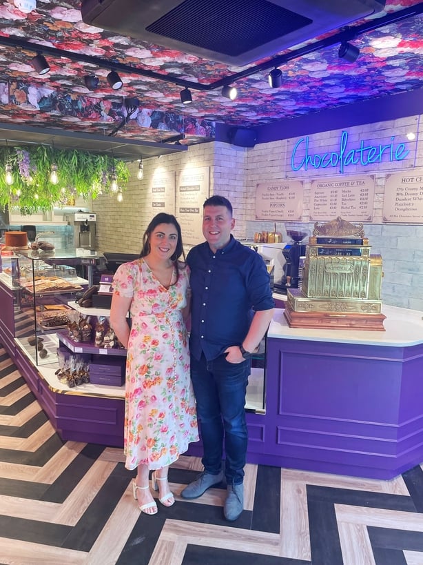 A couple standing in a room with purple and white walls