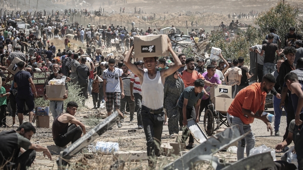 Palestinians carry boxes of humanitarian aid collected from a distribution center in the Netzarim Corridor, central Gaza Strip, on Thursday, May 29, 2025. The US and Israel-backed Gaza Humanitarian Foundation says it opened a fourth distribution site and three of its four sites were fully operationa