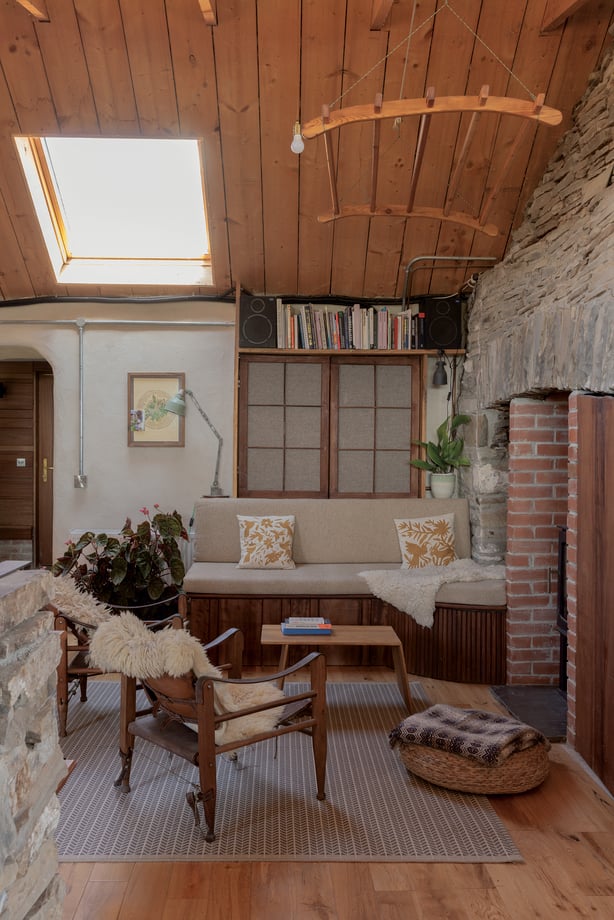 a room with a stone wall and a fireplace