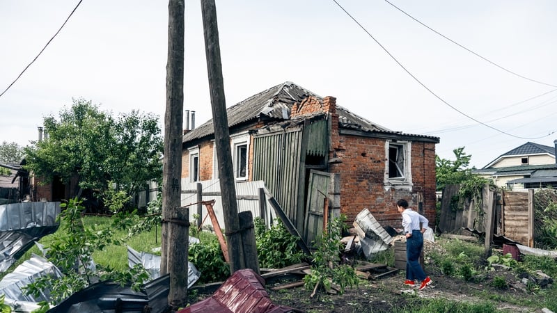 A woman walks amid debris near a damaged house in a residential district hit by a Russian airstrike in Sumy, Ukraine (File image)